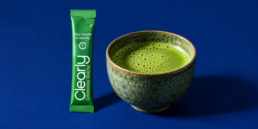 En stick Clearly Matcha bredvid en kopp nyvispad matcha