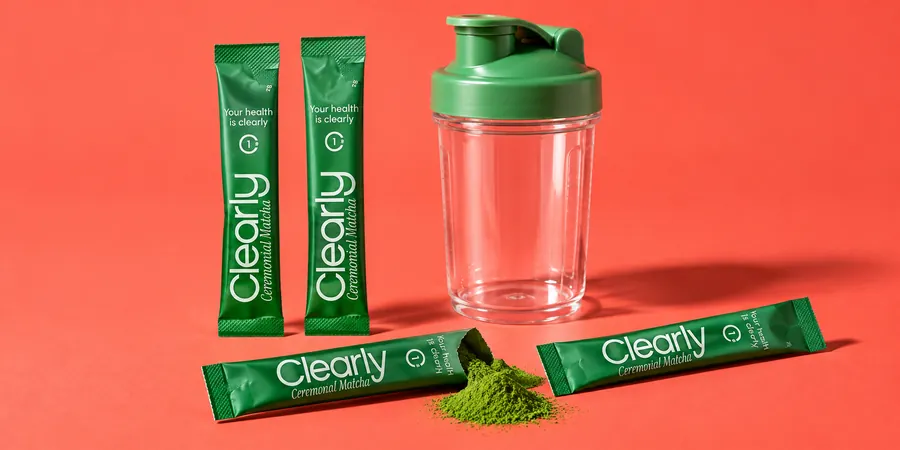 Clearly Matcha i förseglade stickor bredvid en öppnad stick med grönt pulver